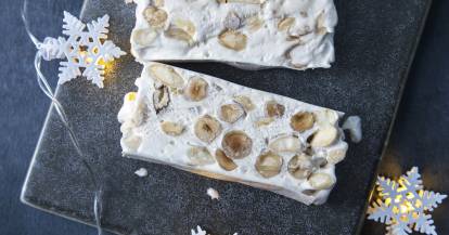 Nougat auf dunklem Untergrund mit Schneeflockenlichterkette 